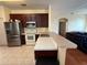 Open kitchen with stainless steel appliances, stone countertop, and breakfast bar that connects to the living area at 2530 Baykal Dr, Kissimmee, FL 34746