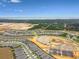 A broad aerial shot of new homes near a construction area, with a lake and greenery in the distance at 2766 Purple Meadow Ct, Minneola, FL 34715