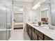 Elegant bathroom with dual sinks, quartz countertops, and a view into the bedroom at 2766 Purple Meadow Ct, Minneola, FL 34715