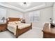 Comfortable bedroom featuring a tray ceiling, natural light, and a wooden bed set at 2766 Purple Meadow Ct, Minneola, FL 34715