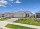 Attractive single-Gathering home shows well-maintained landscaping, a paver driveway, and a convenient two-car garage at 2766 Purple Meadow Ct, Minneola, FL 34715