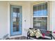 Welcoming front entrance featuring a stylish glass door, bench seating, and vibrant floral accents at 2766 Purple Meadow Ct, Minneola, FL 34715
