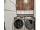 Convenient laundry room with modern appliances, storage cabinets, and ample shelving space at 2766 Purple Meadow Ct, Minneola, FL 34715
