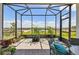 A screened patio with brick flooring and potted plants providing an outdoor living space at 2766 Purple Meadow Ct, Minneola, FL 34715