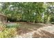 Large, landscaped backyard with mature trees and cozy patio seating area at 2918 Croton Rd, Apopka, FL 32703