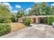 Inviting home exterior with a driveway, carport, and lush surrounding greenery at 2918 Croton Rd, Apopka, FL 32703