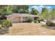 Ranch-style home with tan exterior, mature trees, and well-manicured lawn at 2918 Croton Rd, Apopka, FL 32703