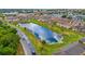 Aerial view showcasing a pond within the townhome community and nearby landscaping at 318 Australian Way, Davenport, FL 33897