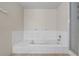 Bright bathtub area featuring a tiled bath with shower and tiled floors, offering a serene and clean aesthetic at 318 Australian Way, Davenport, FL 33897