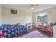 Bright bedroom with ceiling fan, large window, and whimsical decor at 318 Australian Way, Davenport, FL 33897