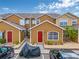 Inviting exterior view with red doors, well-kept landscaping, and convenient parking spaces at 318 Australian Way, Davenport, FL 33897