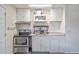 Well-lit kitchen with white cabinetry, essential appliances, and ample countertop space at 318 Australian Way, Davenport, FL 33897