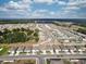 A picturesque aerial view featuring modern single-Gathering homes, scenic landscaping, and a tranquil lake in the distance at 3341 Lounging Wren Ln, Bartow, FL 33830