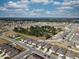 Expansive aerial showcasing neat rows of single-Gathering homes, manicured lawns, and community layout amidst a picturesque landscape at 3341 Lounging Wren Ln, Bartow, FL 33830
