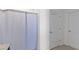 Bright bathroom with a shower featuring a white curtain, complemented by white doors and neutral tiling at 3341 Lounging Wren Ln, Bartow, FL 33830