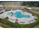 Aerial view of community pool with lounge chairs, palm trees, and a covered gathering area for residents at 3341 Lounging Wren Ln, Bartow, FL 33830