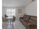 Living room featuring a dining table, a large window, and comfortable sofa at 3341 Lounging Wren Ln, Bartow, FL 33830