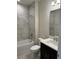 Bathroom featuring marble tiled walls, a tub, a vanity, and modern fixtures at 3450 Mclain Preserve Pt, Sanford, FL 32771
