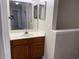 Bathroom vanity with mirror and sink, complemented by neutral wall tones and a glimpse of the hallway beyond at 4001 San Sabastian Dr # 107, Kissimmee, FL 34741