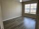 Bright bedroom featuring wood-look floors, a ceiling fan and a large window at 4001 San Sabastian Dr # 107, Kissimmee, FL 34741