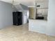 Open-concept living area with tile floors, a breakfast bar, and an adjacent kitchen at 4001 San Sabastian Dr # 107, Kissimmee, FL 34741