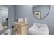 Charming half-bath features a round mirror and palm tree artwork at 404 Taylor Groves Dr, Lake Wales, FL 33853