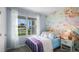 Charming bedroom with mermaid-themed wall art, colorful bedding, and natural light from the window at 404 Taylor Groves Dr, Lake Wales, FL 33853