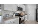 Well-lit kitchen showcasing stainless steel appliances, gray countertops and white cabinetry at 404 Taylor Groves Dr, Lake Wales, FL 33853