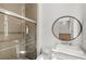 Modern bathroom boasts a glass shower, a round mirror, and a stylish sink at 4047 Isabella Cir, Windermere, FL 34786