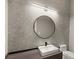 Modern bathroom with a stylish vanity, round mirror, and textured wall at 4047 Isabella Cir, Windermere, FL 34786