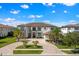 Stunning luxury home featuring a circular paver driveway, lush landscaping, and a grand facade at 4047 Isabella Cir, Windermere, FL 34786
