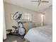 Neutral toned bedroom with an elliptical machine, framed artwork and a dresser at 428 Bel Air Way, Kissimmee, FL 34759