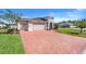 Charming home featuring a two-car garage, brick driveway, and a neatly landscaped front yard at 428 Bel Air Way, Kissimmee, FL 34759