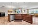 Kitchen island featuring a stainless steel dishwasher, granite countertops, and wood cabinetry at 428 Bel Air Way, Kissimmee, FL 34759