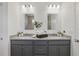 Elegant bathroom featuring a double vanity with granite countertops, modern lighting, and stylish mirrors at 4338 Davos Dr, Clermont, FL 34711