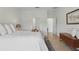 Bright bedroom with a queen bed, wood-style flooring, neutral tones, and hallway view at 4338 Davos Dr, Clermont, FL 34711