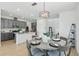 Open-concept dining area featuring a modern light fixture and a seamless connection to the kitchen at 4338 Davos Dr, Clermont, FL 34711