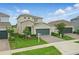 Inviting two-story home showcasing stone elements, a paved driveway, and manicured landscaping at 4338 Davos Dr, Clermont, FL 34711