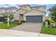 Charming two-story home with a stone facade, a paved driveway, and a well-manicured lawn at 4338 Davos Dr, Clermont, FL 34711