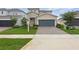 Charming two-story home with stone accents, a well-manicured lawn, and a brick driveway at 4338 Davos Dr, Clermont, FL 34711