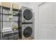 Convenient laundry room with modern, stackable washer and dryer, plus storage shelves at 4338 Davos Dr, Clermont, FL 34711