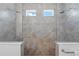Modern tile shower with dual showerheads, glass doors, and bright windows at 4338 Davos Dr, Clermont, FL 34711