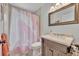 Bathroom with a vanity, framed mirror, shower with curtain, providing essential amenities at 440 E Crystal Lake St, Orlando, FL 32806