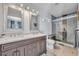 Bathroom with a double sink vanity, framed mirrors, a walk-in shower with glass door, and tile flooring at 440 E Crystal Lake St, Orlando, FL 32806