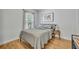 Neutral bedroom with a comfortable bed, bedside table, wood-look floors and bright natural light at 440 E Crystal Lake St, Orlando, FL 32806