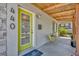 Inviting front porch with natural wood accents, decorative chairs and a vibrant green door at 440 E Crystal Lake St, Orlando, FL 32806