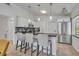 Stylish kitchen with white cabinetry, stainless steel appliances, black countertop, and pendant lighting at 440 E Crystal Lake St, Orlando, FL 32806