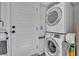 Laundry area featuring a stacked washer and dryer unit and door, maximizing space and convenience at 440 E Crystal Lake St, Orlando, FL 32806