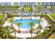Stunning aerial view of a luxurious community pool surrounded by palm trees and lounge chairs at 4731 Clock Tower Dr # 104, Kissimmee, FL 34746