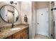 A bathroom featuring a wood vanity with granite countertops and a framed round mirror at 4819 Shoreline Cir, Sanford, FL 32771